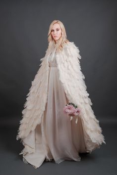 "Luxurious ivory ostrich feather plume cape inspired by Swan Lake. 100% real feathers hand applied to the base fabric. Cape is fully lined and has a double sided satin ribbon for tying a bow. Perfect for your wedding or any other special occasion. Please specify size by supplying measurements of height and circumference around shoulders and neck. Product shown in size small, ivory feathers with an extra length of 8\". These feathers are a light ivory to champagne color depending on the type of l Feather Cloak, Angelic Style, Tying A Bow, Feather Outfit, Feather Cape, Feather Gown, Feather Coat, Swan Dress, Feather Fashion