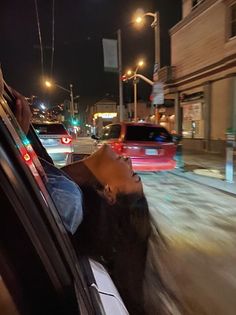 a man sitting in the passenger seat of a car talking on his cell phone at night