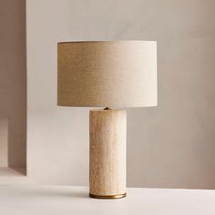 a lamp that is on top of a table next to a white wall and floor