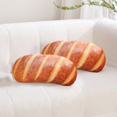 two pieces of bread sitting on top of a white couch