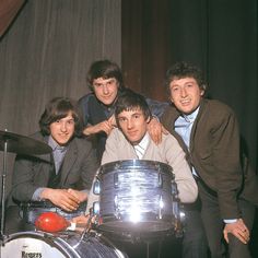 the beatles posing for a photo in front of their drum kit