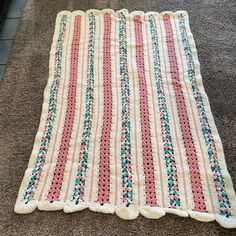 a crocheted blanket is laying on the floor