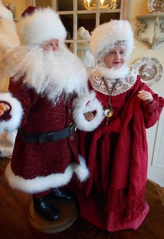 two people dressed up as santa claus and mrs claus, standing next to each other