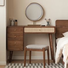 a bedroom scene with focus on the dressing table and stool, which has a round mirror above it