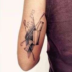 a man with a tattoo on his arm holding a baseball bat and ball in it