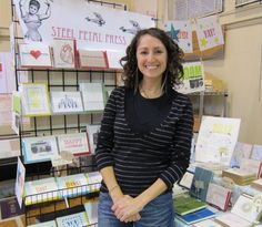 a woman is standing in front of some greeting cards