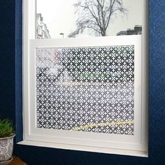 a window in a room with blue walls and white trim on the windowsill, next to a potted plant