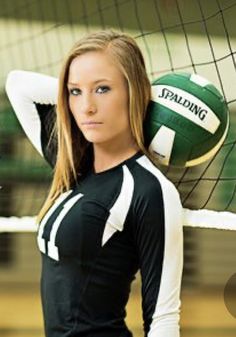 a beautiful young woman standing next to a volleyball ball