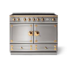 an old fashioned stove with two burners and gold knobs on the front, against a white background