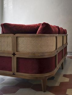 a red couch sitting on top of a tiled floor