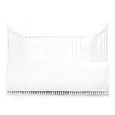 a baby crib with white sheets on it