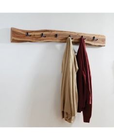 a coat rack with two coats hanging from it's hooks on a white wall