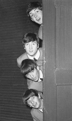 the beatles peeking out from behind a door