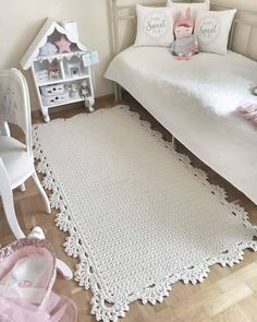 a white bed sitting next to a wooden floor in a room filled with furniture and accessories