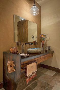 a bathroom sink sitting under a mirror next to a wooden counter top with lights above it