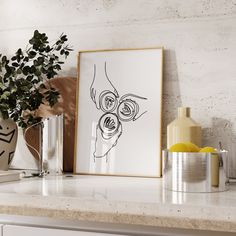 an art work is displayed on a shelf next to a potted plant and two vases