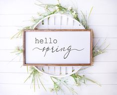 a sign that says hello spring hanging on a wall