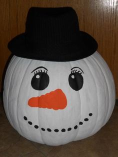 a white pumpkin with a black hat on it