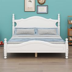 a white bed sitting in a bedroom next to a blue wall