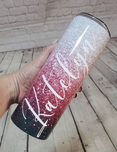 someone is holding up a pink and silver glitter tumbler