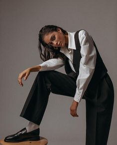 a woman sitting on top of a wooden stool