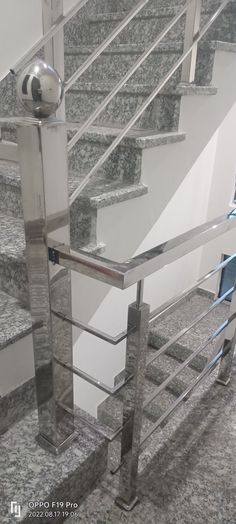 the stairs are made of glass and metal with silver railings on each handrail