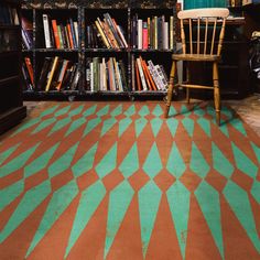 a chair sitting in front of a bookshelf filled with lots of bookcases