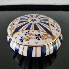 a blue and white box sitting on top of a black table next to a wall