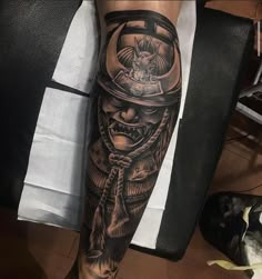 a man's leg with a tattoo on it and an image of a demon