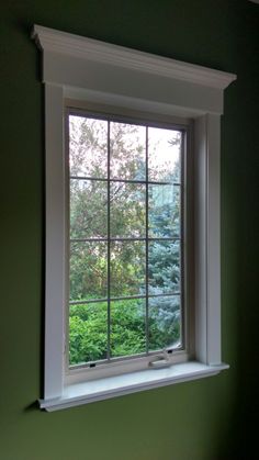 a window in a green room with trees outside