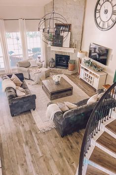 a living room filled with lots of furniture and a spiral staircase leading up to the second floor