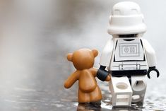 a lego star wars character holding the hand of a teddy bear