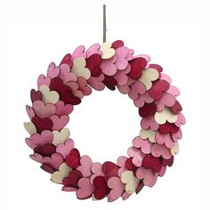 a pink and red wreath with hearts hanging from it