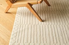 a wooden chair sitting on top of a white rug