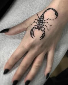 a woman's hand with a scorpion tattoo on it