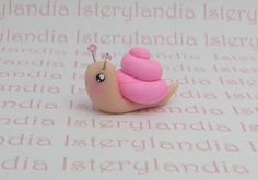 a small pink snail sitting on top of a piece of paper