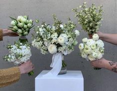 four people holding bouquets of flowers in their hands