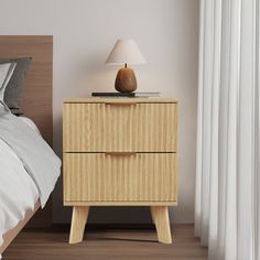 a nightstand with a lamp on it next to a bed