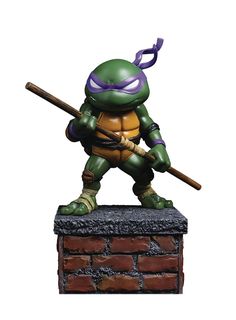 a statue of a teenage mutant holding a baseball bat on top of a brick wall