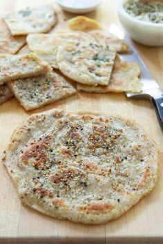 some flat breads are on a cutting board