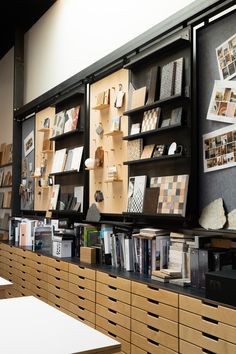 the shelves are full of books and pictures on display at the library's front desk