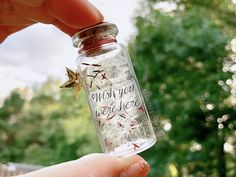 someone is holding up a tiny bottle with some writing on it that says make a wish