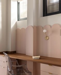 a desk with a chair and a mirror on the wall above it in a room