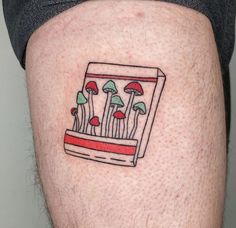 a small tattoo on the leg of a man's thigh with mushrooms in a box