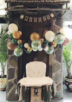 a chair sitting in front of a table with balloons on it