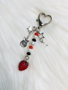 a keychain with a heart, star and guitar charm on it's side