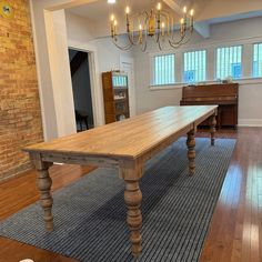 a large wooden table sitting in the middle of a living room next to a piano