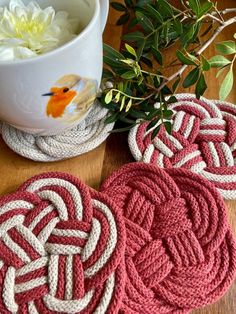 four coasters on a table with flowers and a cup in the backgrouf