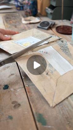 a person cutting paper on top of a wooden table