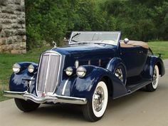 an antique car is parked on the side of the road